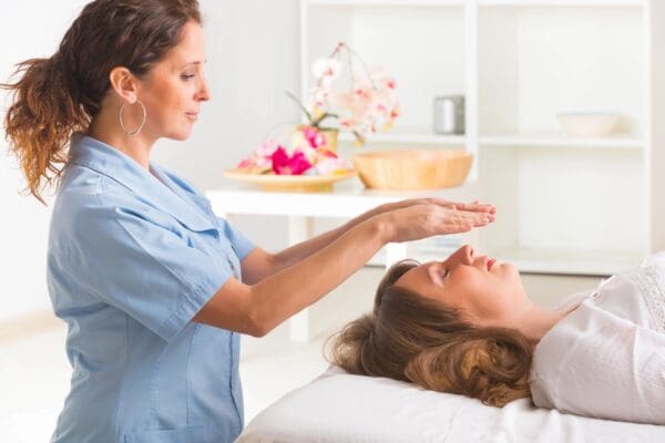 A woman is getting reiki treatment from an expert.