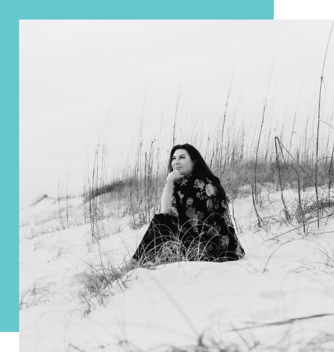 A woman sitting in the snow on top of a hill.